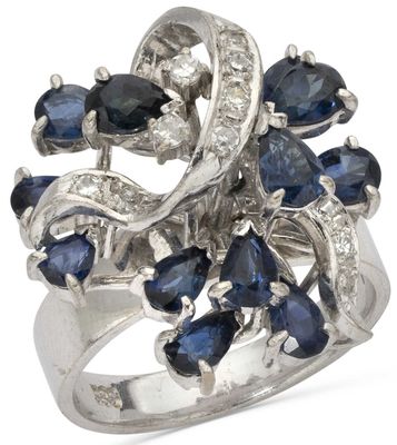 a close up of a ring with blue sapphires and diamonds