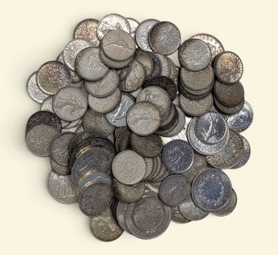 une pile de pièces d'argent posée sur une surface blanche