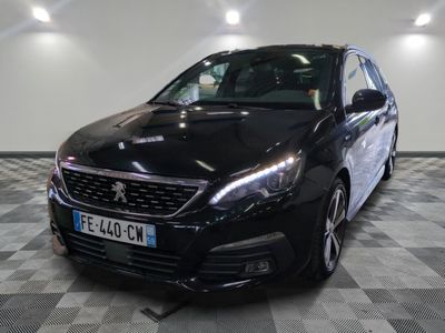 La voiture noire est garée sur le sol à damier du garage.