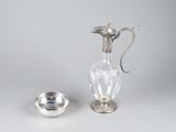 une assiette en argent et un pichet en verre posés sur une table