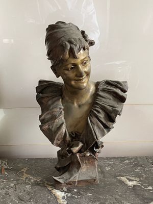 a bronze bust of a woman with a ruffled collar