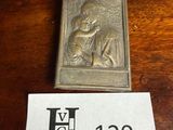 une petite plaque métallique sur laquelle figure le portrait d'une femme