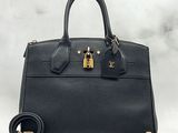 a black handbag with a gold lock on the handle