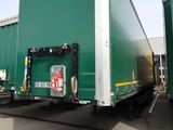 deux semi-remorques verts garés côte à côte sur un parking