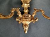 a gold wall sconce on a black background