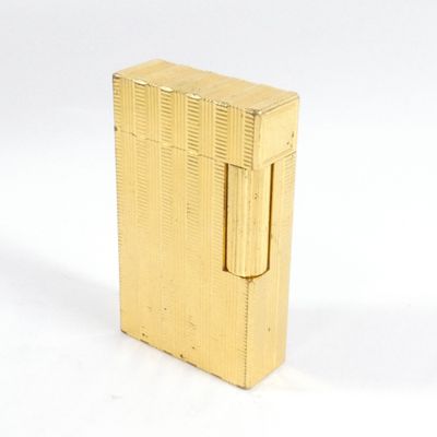 un briquet doré posé sur une surface blanche