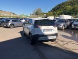 a lot of cars parked in a parking lot on the side of the road