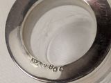a close up of a silver ring on a white surface
