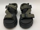 a pair of black and green sandals on a white surface