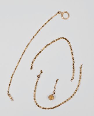 un ensemble composé d'un collier et de boucles d'oreilles en or sur fond blanc