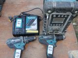 two corded drillers sitting on top of a piece of wood