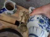 a person pouring tea into a blue and white tea pot
