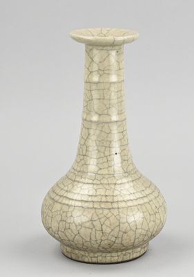 un vieux vase blanc à la peinture écaillée posé sur une table