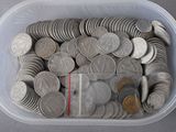 a plastic container filled with lots of coins on a table