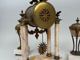 a clock that is sitting on top of a marble stand