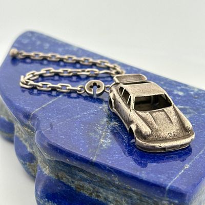 a silver car on a blue stone with a chain around it