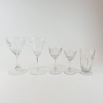 four wine glasses are lined up in a row on a white surface