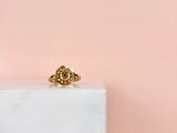 une bague en or posée sur un bloc de marbre blanc
