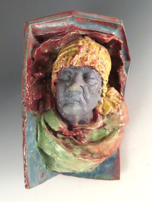 une sculpture en céramique représentant une femme portant un foulard autour de la tête