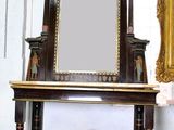 a mirror sitting on a table next to a mirror on the wall