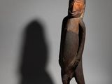 an old wooden statue of a man with a helmet on his head