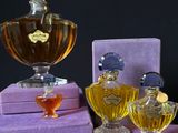 purple boxes with perfume bottles sitting on top of them on a table