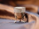 a silver cup sitting on top of a cloth