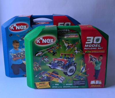 deux boîtes de jouets k ' nex avec un garçon jouant avec une petite voiture