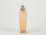 un flacon de parfum posé sur une surface blanche