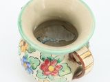 a small cup with a handle on a white surface