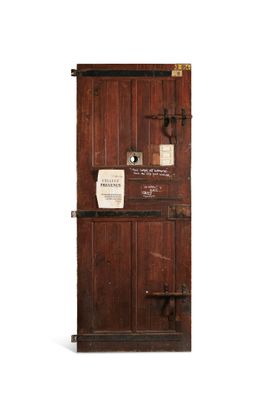 an old wooden door with a sign on it