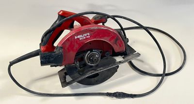 une photo d'une scie circulaire rouge posée sur une surface blanche
