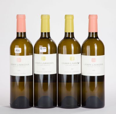 trois bouteilles de vin posées les unes à côté des autres sur une surface blanche