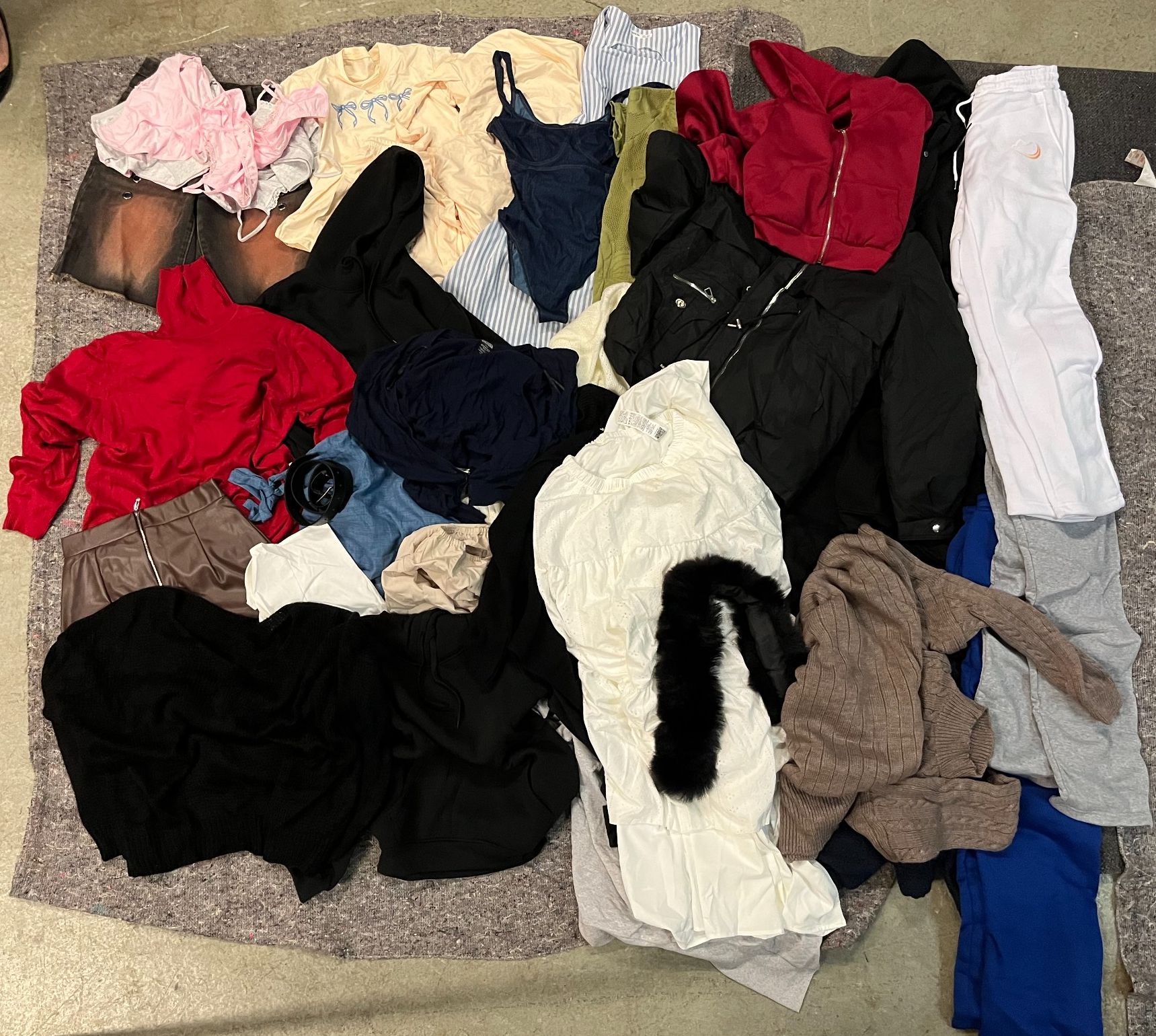 Un ensemble de vêtements et fripe, pour homme et femme, principalement neufs, comportant t-shirts, pulls, vestes, jog...