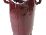 a red vase that is sitting on a white surface