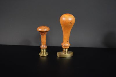 une paire de bougeoirs en bois et en laiton posés sur une table noire