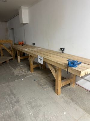 a long wooden bench in the middle of a room