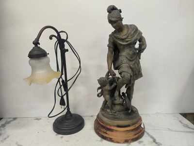 une statue représentant un homme avec un chien à côté d'un lampadaire