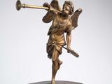 a statue of an angel holding a trumpet on top of a clock