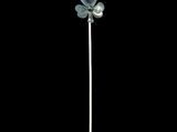 a silver flower on a stick on a black background
