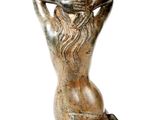 statue of a woman sitting on a rock with her hands behind her head