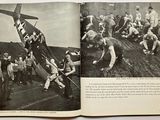 an open book with a picture of a group of men standing around a plane
