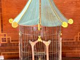 a bird cage with a bird inside of it on a table