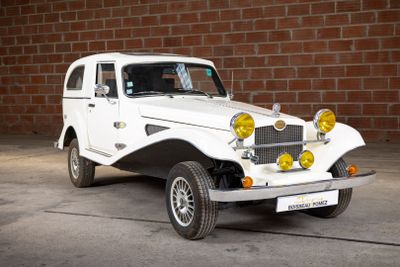 a white car that is parked in front of a brick wall