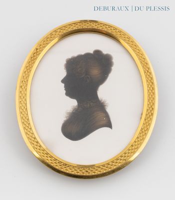 une photo ancienne représentant une femme de profil, dans un cadre doré