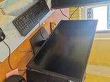 a computer desk with a monitor, keyboard, mouse and monitor