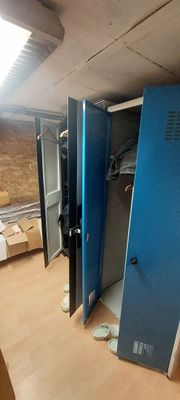 several blue lockers in a room with boxes and boxes on the floor