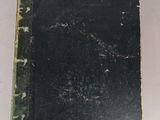 an old book sitting on top of a table next to a white table