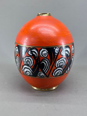 un vase orange orné de motifs noirs et blancs