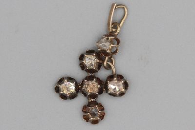 une petite croix en cristaux sur un fond blanc